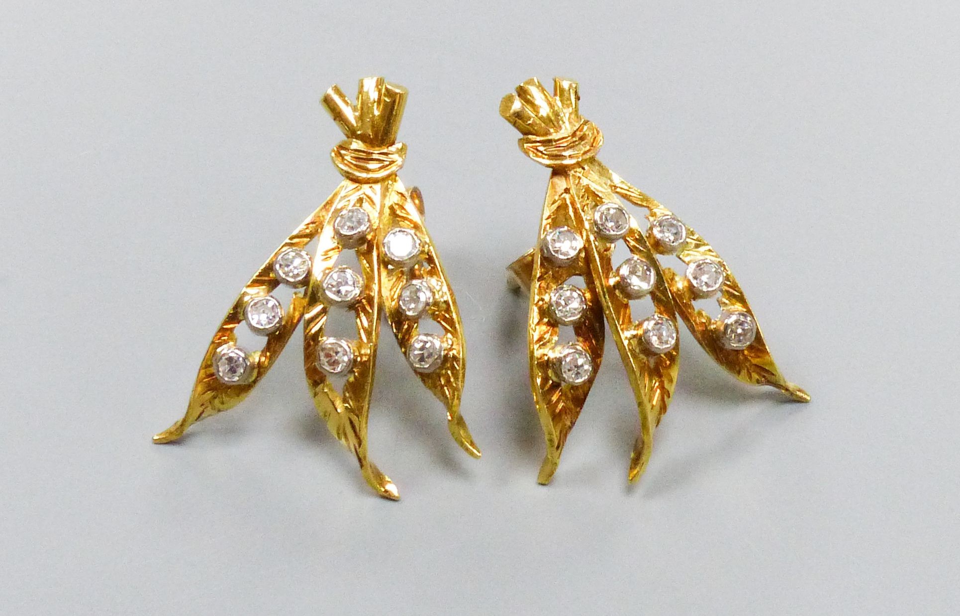 A pair of modern yellow metal and nine stone diamond chip set triple leaf earrings, 20mm, gross weight 3 grams.